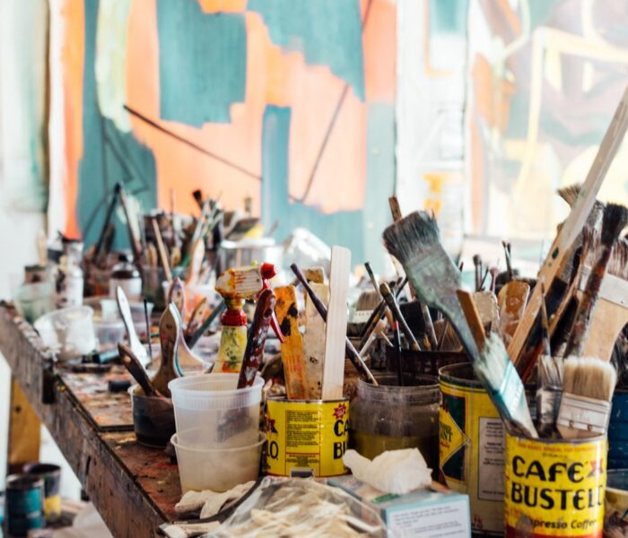 Featured Image for What is Cretivity? Evolution of Theories in Psychology - Painting Brushes and utensils on a table inside an art studio