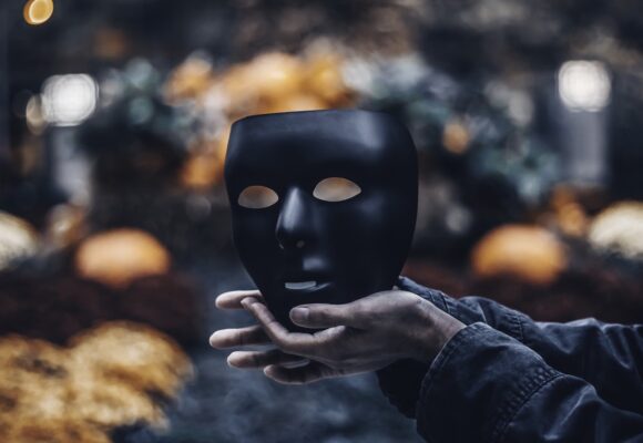 Featured Image for Dealing with Impostor Syndrome: Here is what you need to know - Photograph of a man holding a mask